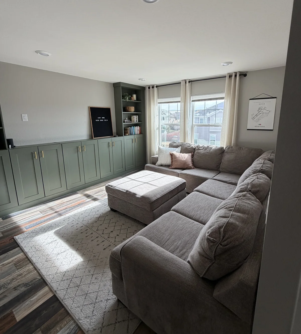 Green built-in cabinetry beside a living-room window.