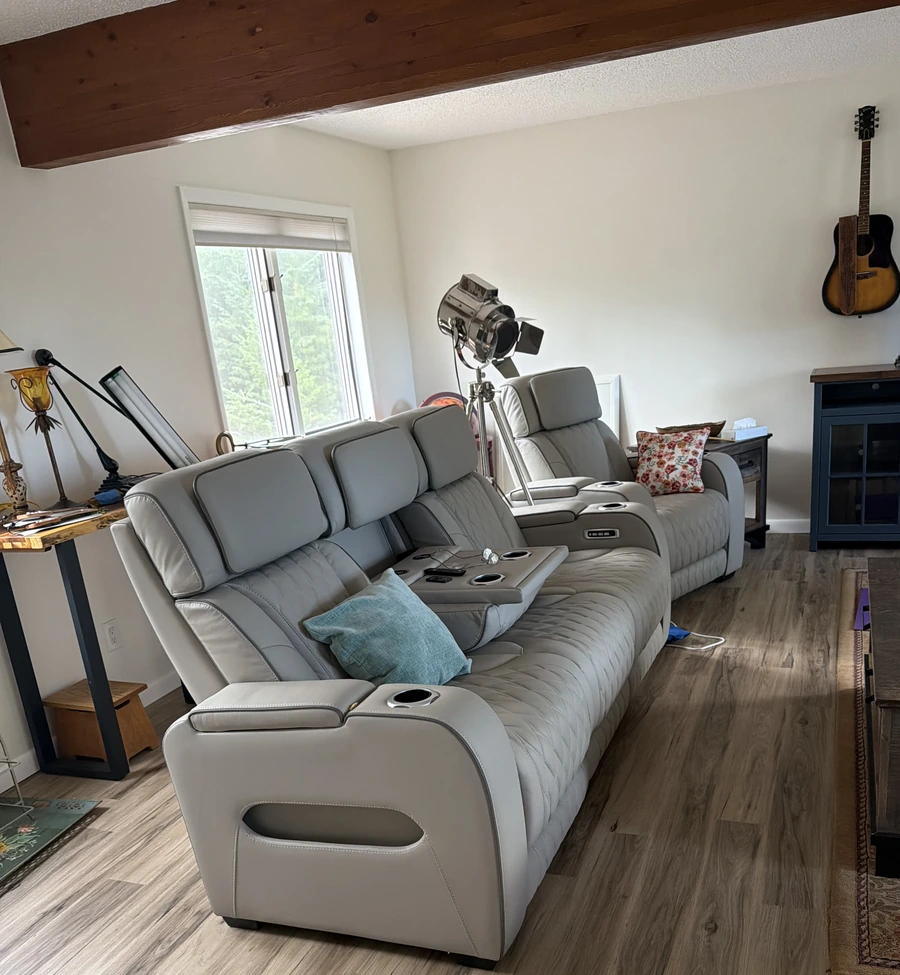 Living room with plank flooring and gray reclining sofas.