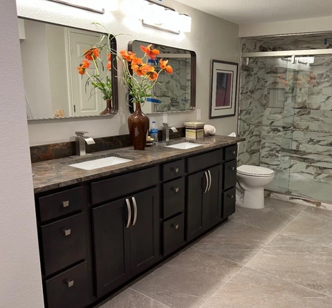 Double vanity beside a stone-pattern shower.